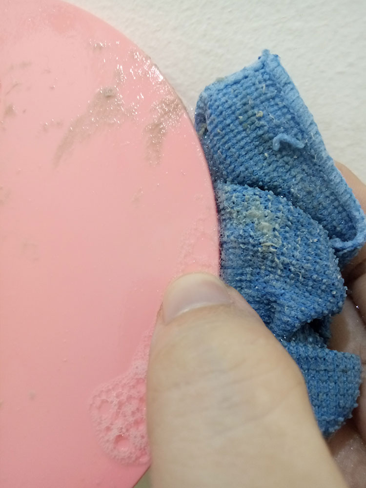 washing sticky figure base with dishwashing liquid and microfiber cloth